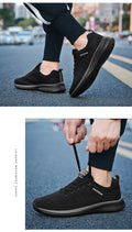 Men's Lightweight Running Sneakers in black being laced up, perfect for casual and sporty looks.