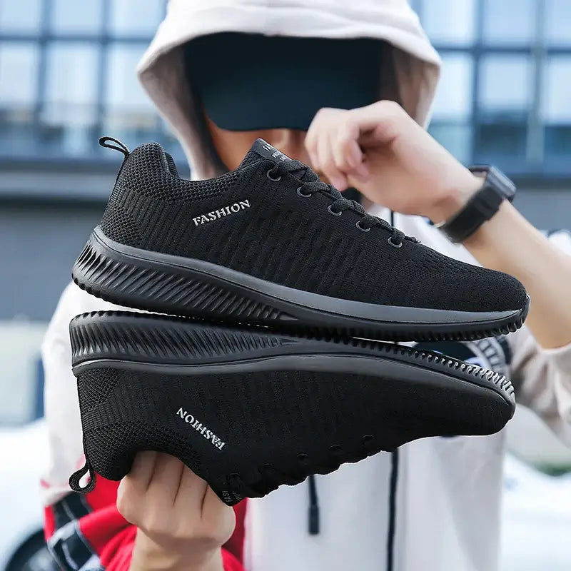 Men's Lightweight Running Sneakers in black being laced up, perfect for casual and sporty looks.
