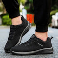 Men's Lightweight Running Sneakers in black being laced up, perfect for casual and sporty looks.