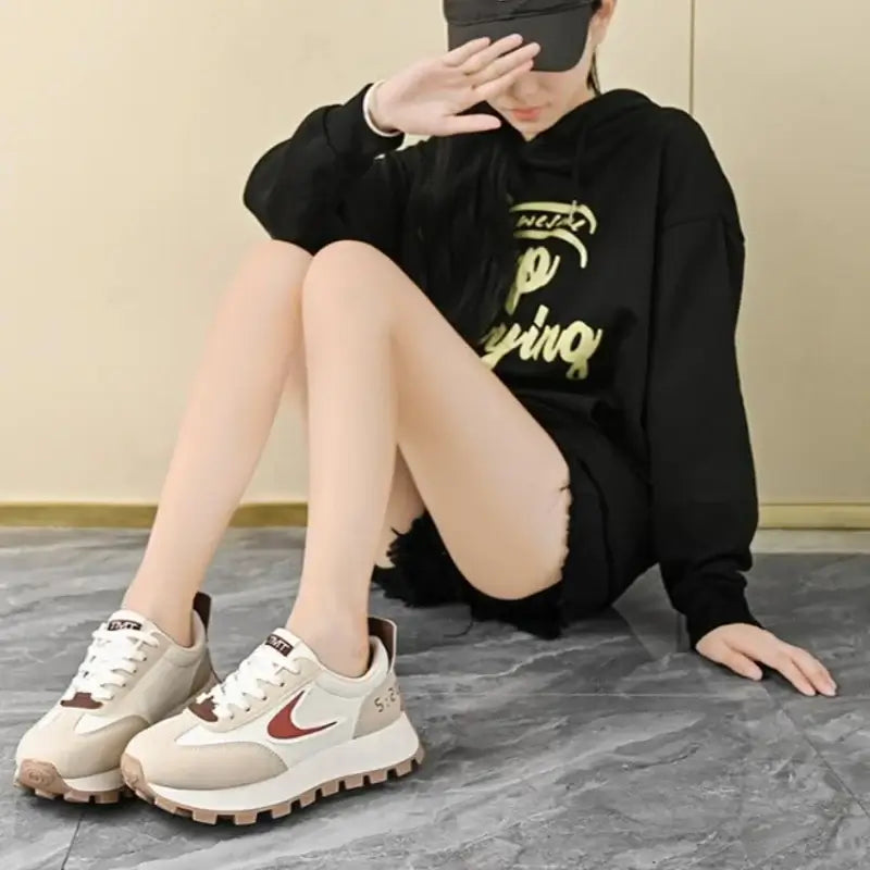 Women Breathable Casual Sneakers worn with a black hoodie, showcasing light comfort shoes in a stylish setting.